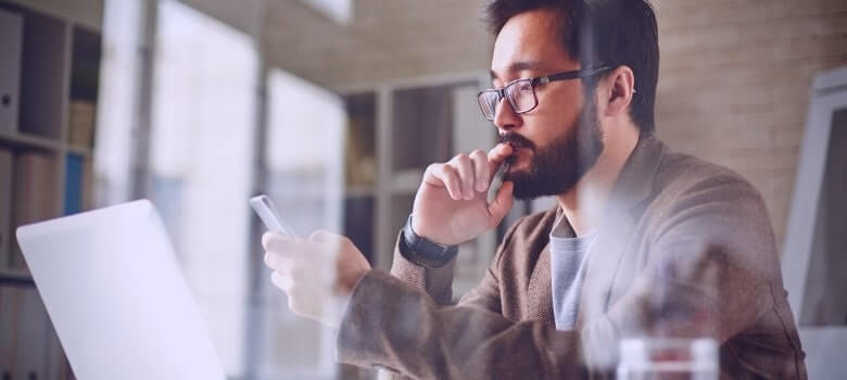 Imagem de um homem olhando no celular o Curso de Gestão de provedores