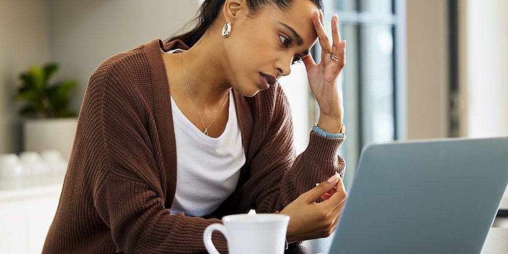 Mulher preocupada com a crise, em frente ao computador